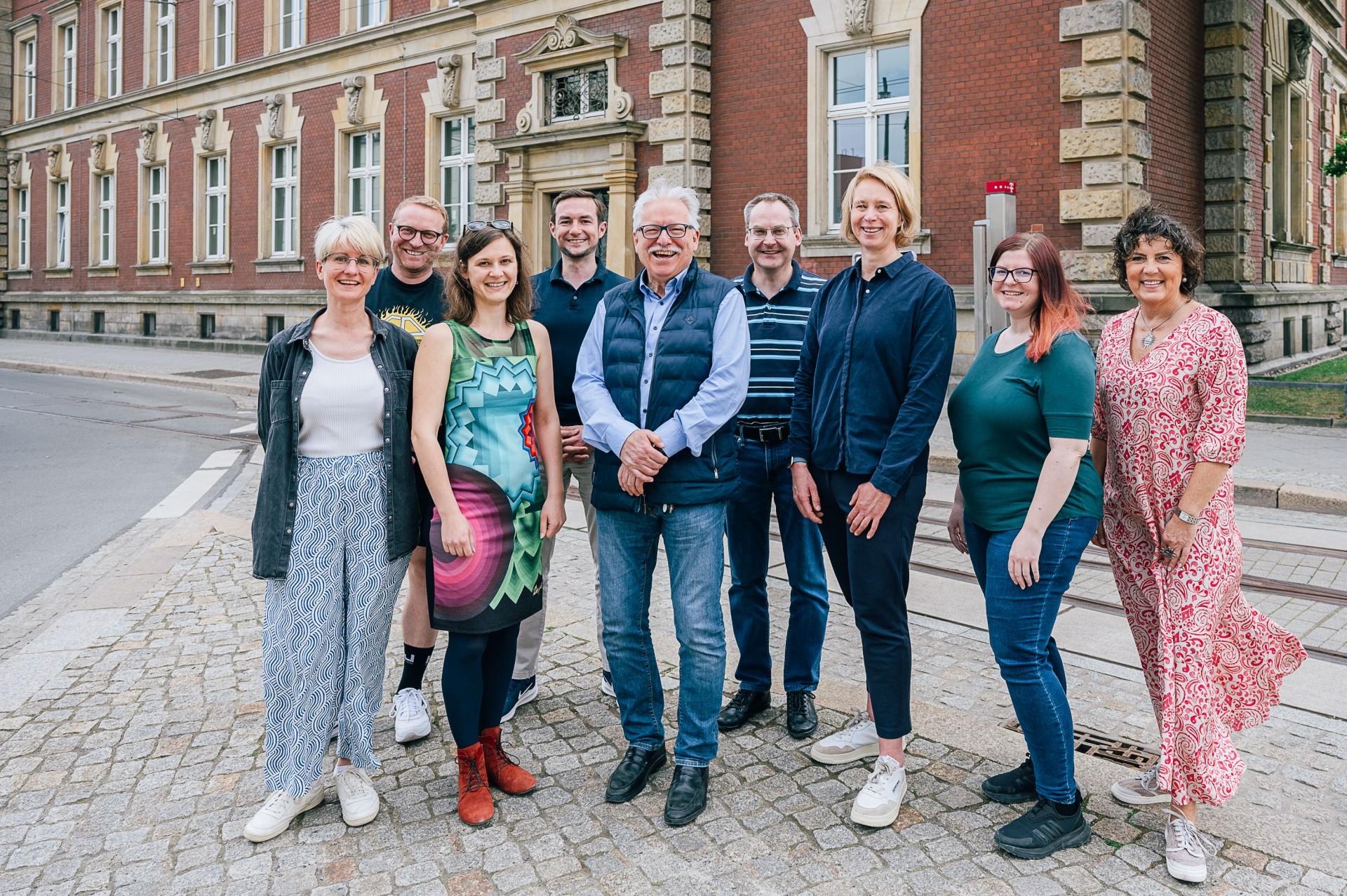 Eine Gruppe von DZA-Mitarbeitenden steht vor dem DZA-Gebäude